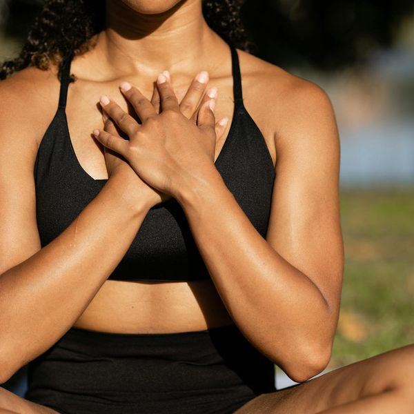 Person stretching outdoors in nature, feeling calm and balanced.